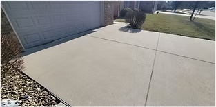 Concrete driveway before pressure washing — oil stains and grime